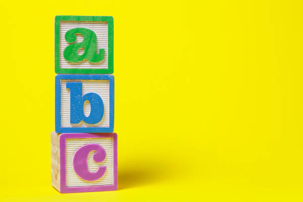 ABC Alphabet blocks stacked up on yellow background