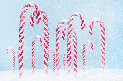 Peppermint Candy Canes and other Christmas decorations on wooden background, selective focus