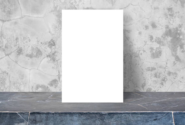 istock Blank White paper poster on stone table top at concrete wall 644925678