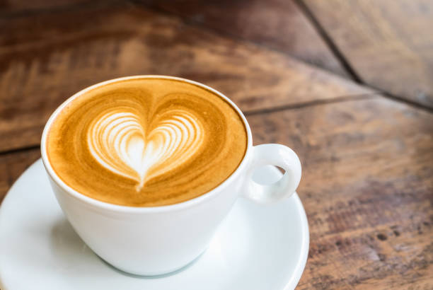 istock Close up white coffee cup with heart shape latte art on wood table at cafe 644929052