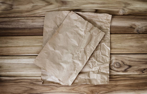 Crumbled cooking or baking paper sheet place on wooden table stock photo