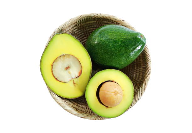 The basket of fresh avocado fruits on white background. stock photo