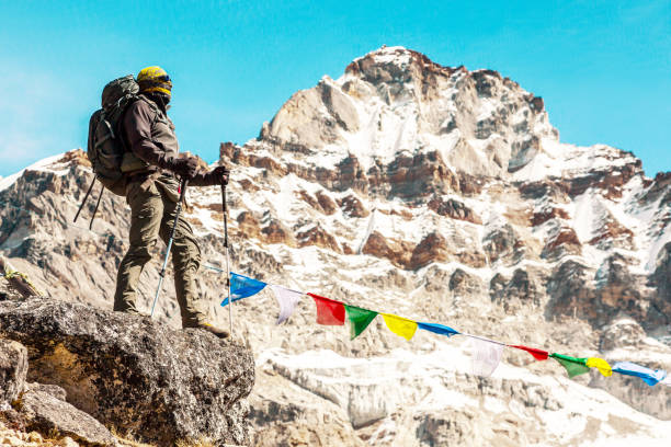 istock Mature Mountain Climber staying on Stone Top in high Mountains 644963026