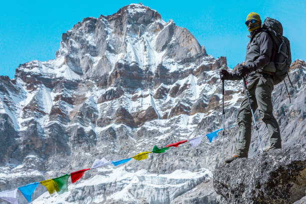 istock Male Mountain Climber staying on Stone Top in high Mountains 644963176