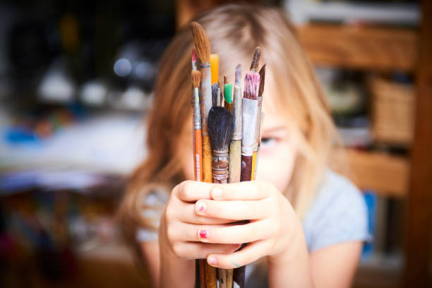 istock Little child blond girl holding a brushes 644966640