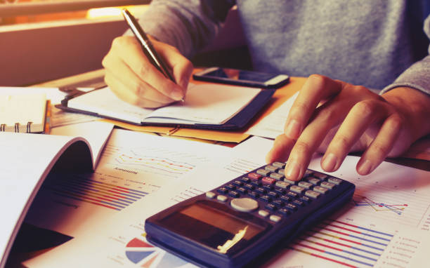 istock Young man using calculator and writing note and calculate finance 644974344