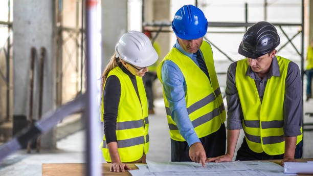 istock Businessman asking questions and pointing to construction blueprint 644977176