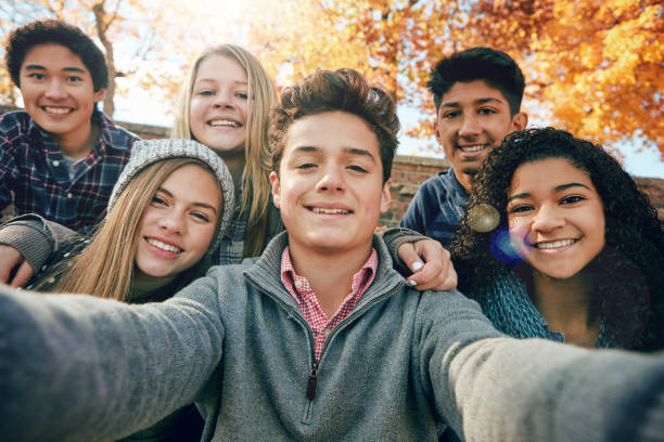 But first, let's take a selfie Portrait of a group of young friends posing for a selfie together outside boy and girl looking at camera stock pictures, royalty-free photos & images