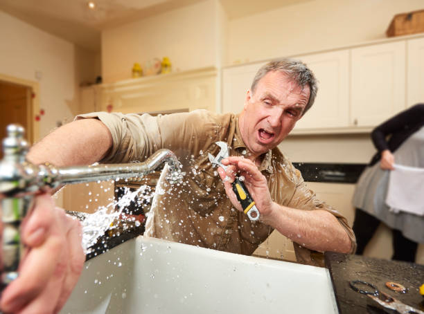 DIY plumber give it a go DIY hero tries his hand at fixing the tap . His wife is already on hand with a towel but jumps out of the way when she sees the leak he has unleasehed . faucet leaking pipe water stock pictures, royalty-free photos & images