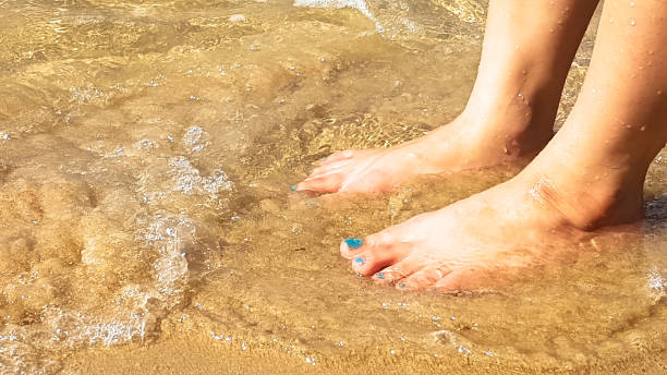 istock woman's leg put in the clearly sea wave 644994692