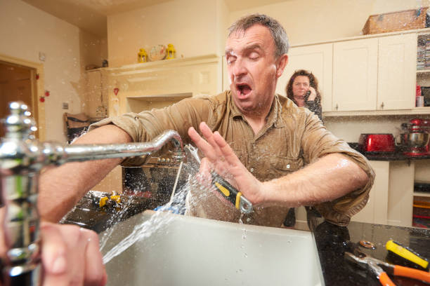 couple ayant une fuite d'eau dans la cuisine nécessitant d'appeler un plombier Genappe