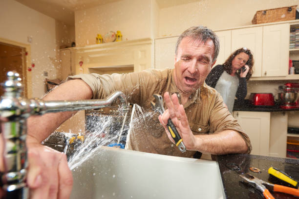 plumbing mishap give it a go DIY hero tries his hand at fixing the tap . His wife is already on the phone to an emergency plumber as water gushes from the broken tap water pipe stock pictures, royalty-free photos & images