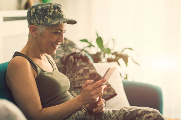 istock Military mature woman using smart phone at home 644998144