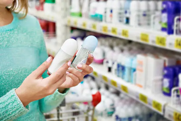 Woman in shop chooses deodorant closeup