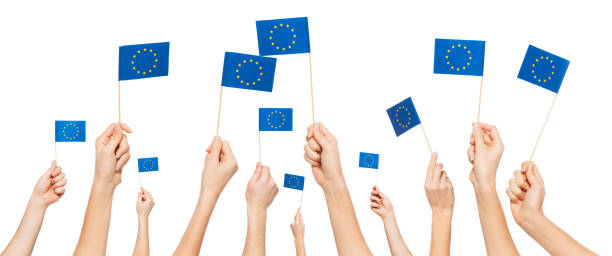 istock Hands holding and raising European Union flags 645002550