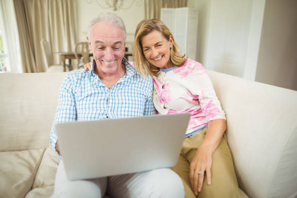 istock Senior couple using laptop in living room 645005074