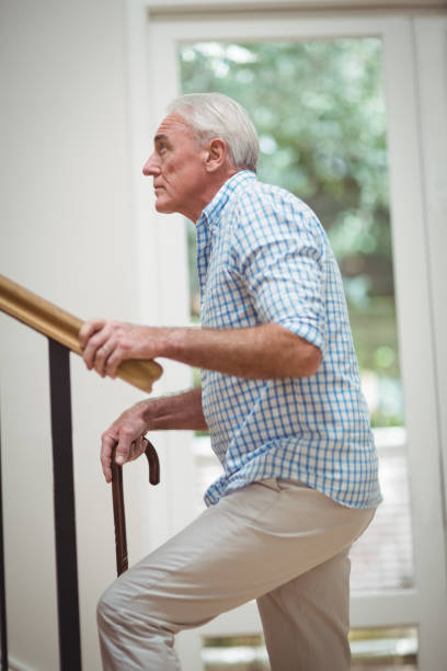 istock Senior man climbing upstairs with walking stick 645005602