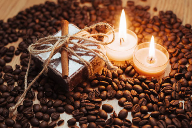 Burning aromatic coffee candle and coffee beans, close-up.