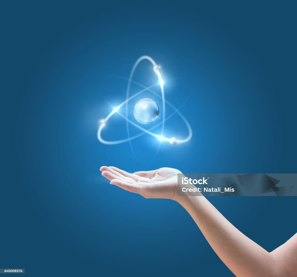 Hand mit dem Atom-Bild auf blauem Hintergrund. - Lizenzfrei Atom Stock-Foto