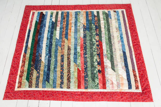 istock Patchwork quilt lies on a white wooden floor. Part of patchwork quilt on a white background. Handmade 645012010
