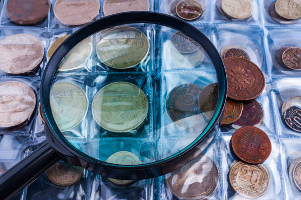 Magnifying glass and old coins stock photo