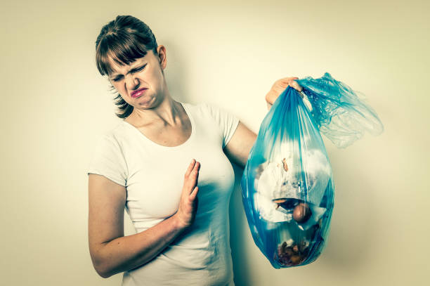 Woman holding a smelly garbage bag