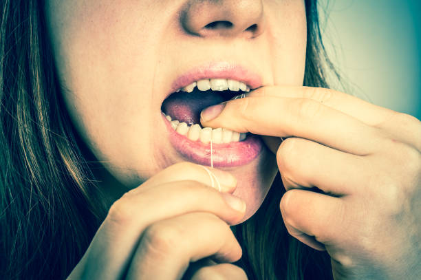 istock Woman flossing teeth with dental floss 645027746