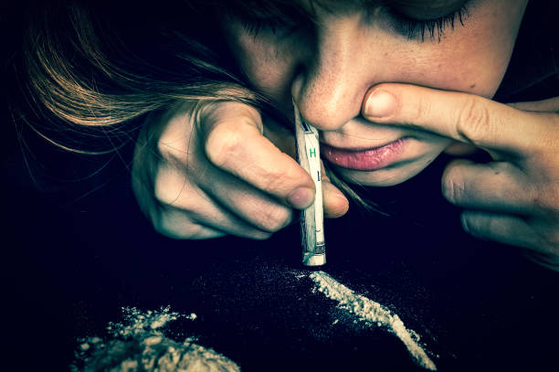 junkie woman snorting cocaine powder with rolled banknote - narcotic teenager cocaine drug abuse imagens e fotografias de stock