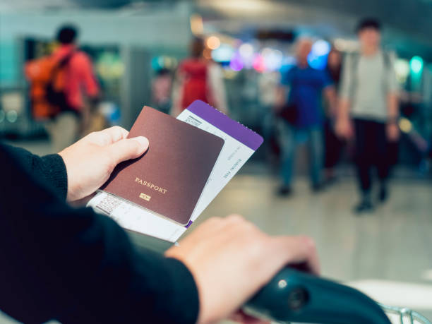 istock Hand holding Passport boarding pass ticket at Airport 645034324