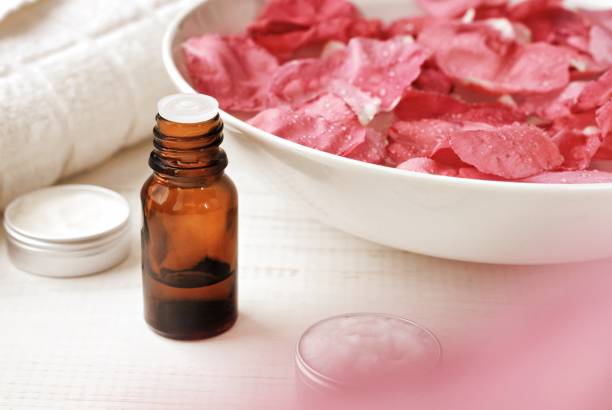 ciotola di petali di rosa rosa, olio essenziale, trattamenti per il viso. - infused oil immagine foto e immagini stock