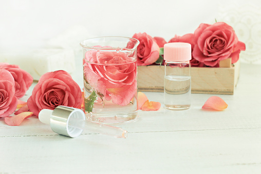 Tónico facial de rosa casero. Tarro de esencia de flor, botella, pipeta de cristal. photo