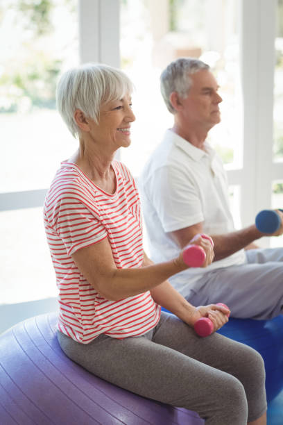 istock Senior couple exercising with dumbbells on exercise ball 645045568