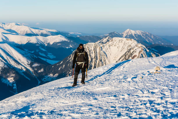 istock Mountaineer with ice axes and backpack in mountains in winter. 645051754
