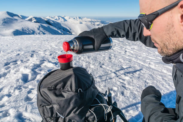 istock Hiker pours hot tea from a thermos in the mountains. 645060334