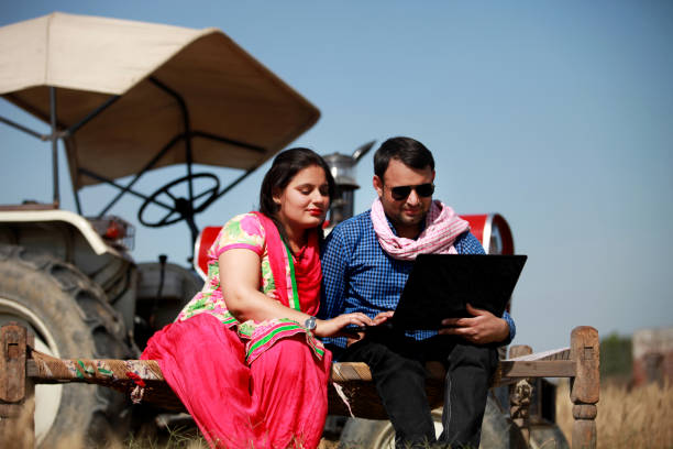 istock Indian couple using laptop in the field 645064502