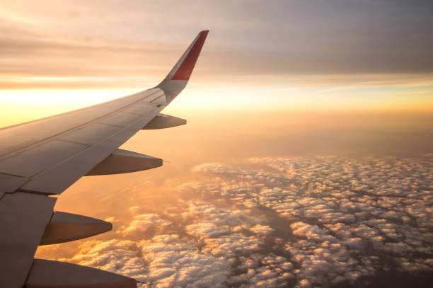 istock Sunset time and flare with airplane wing from the inside. 645071172