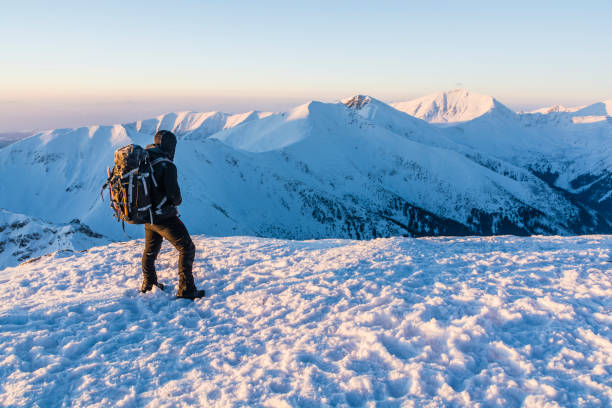 istock Man with the backpack enjoy mountain views in winter. 645072562