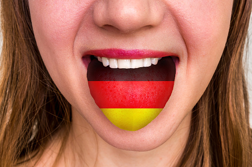 Woman with german flag on the tongue - learning a foreign language