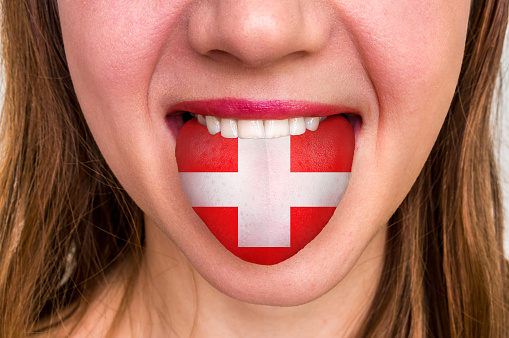 Woman with swiss flag on the tongue - learning a foreign language