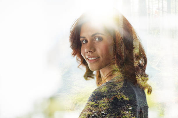 Multiple exposure shot of young businesswoman superimposed over a forest landscape