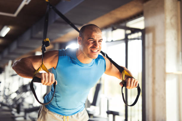 istock TRX suspension training- athletic man doing arm exercises 645085316
