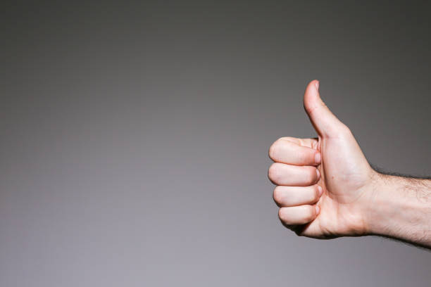 istock Man's thumb up sign on a grey background 645086480