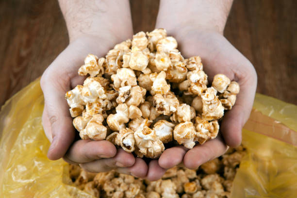 istock people gaining a bunch of popcorn from the package 645089336