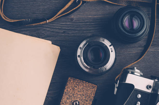 istock Old camera and lenses on dark wooden background 645092630