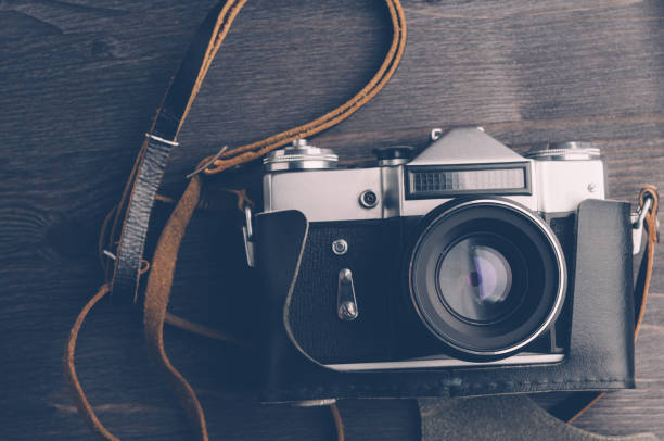 istock Old camera and lenses on dark wooden background 645092782
