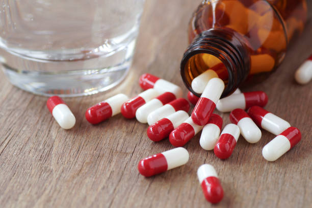 istock capsule and glass on bottle pouring on wood table 645114964