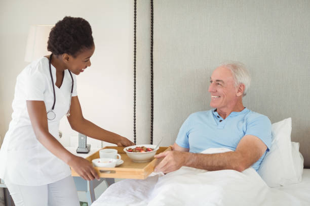 istock Nurse serving breakfast to senior patient 645121694