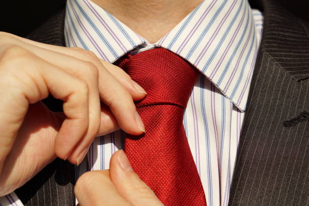 istock Male hands adjusting a red tie around a neck 645123028