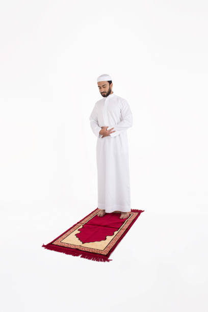 istock Arab muslim man praying on a red carpet 645124060