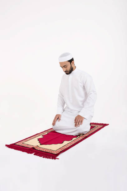 istock Arab muslim man praying on a red carpet 645124270
